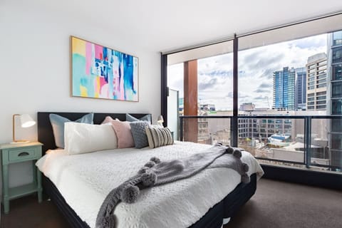 Rest easy in the plush king bed, offering chic artwork and sprawling views across the CBD.