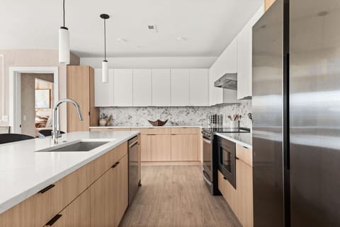 A fully equipped kitchen, stocked with coffee, tea, and condiments, along with a dining table to enjoy homemade meals.