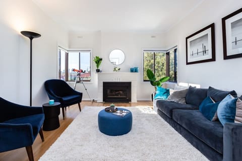 The cosy lounge area offers a velvet couch and armchairs, plus an electric fireplace.