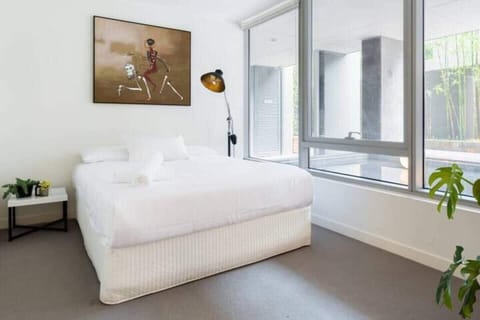 Retreat to a plush queen bedroom with mirrored built-ins and a reading lamp.