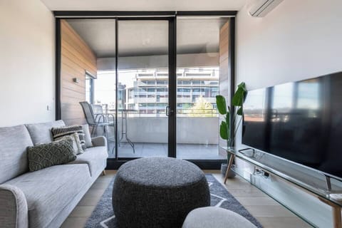 A lounge offers relaxation and comfort and features a plush sofa with pillows, soft ottomans, a rug and a wide-screen TV