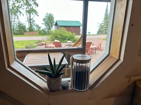 Kitchen window in front of table. Fair trade organic coffee. Cabin 1 seen in background.