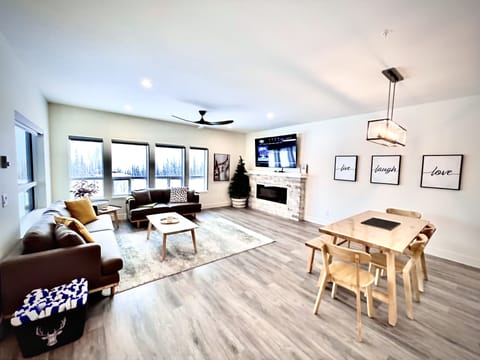 Open living room with electric fireplace and large smart TV with cable