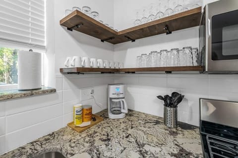 Open shelving with plenty of coffee cups, glasses, and wine glasses