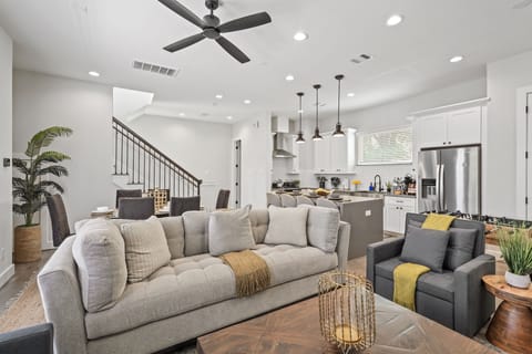 Bright open living room with modern kitchen, cozy seating, and stylish decor.
