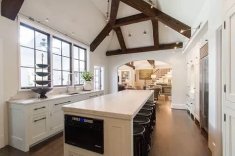 Kitchen with vaulted ceilings with La Cornue CornuFé stove & marble countertops