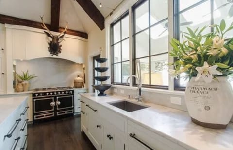 Kitchen with vaulted ceilings with La Cornue CornuFé stove & marble countertops