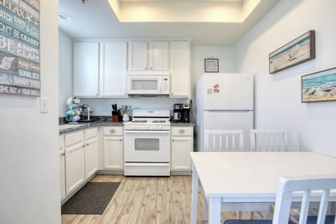 The fully equipped kitchen has a refrigerator, stove and oven, microwave, k-cup coffee maker, and dish ware—everything you need to whip up meals or enjoy a fresh cup of coffee before heading to the beach.