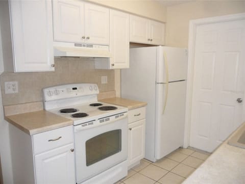 Kitchen with electric stove and full size fridge