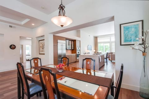 View of dining table with kitchen and hallway in background