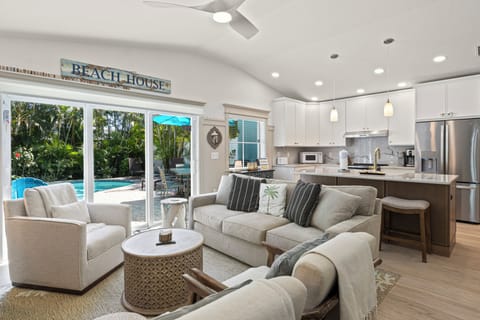 Sink into plush sofas in your open-concept living space, where coastal charm meets modern luxury and pool views beckon through sliding doors.