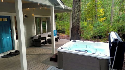 Hot tub with lush forest backdrop. 