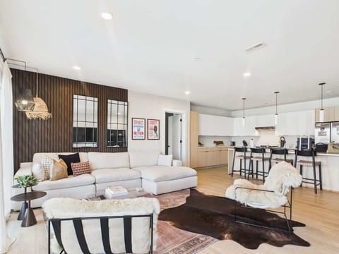 Cozy modern living room featuring a Smart TV, Patio access with city views and designer decor with plush furnishings.