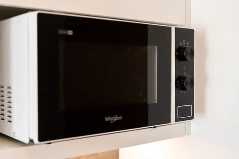 A close-up of a modern microwave placed on a countertop, showcasing a practical and stylish kitchen appliance.