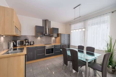 A kitchen-dining area with a modern table, black cabinetry, and a well-organized layout.
