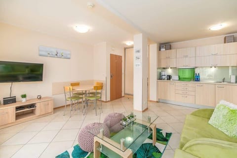 A compact dining area with a round table, chairs, and large windows letting in light.