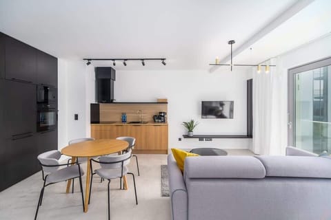 A closer look at the kitchen, featuring wooden cabinetry, built-in appliances, and a compact dining area.
