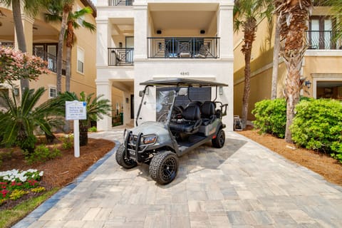 Modern vacation rental complex with tropical landscaping and convenient golf cart parking at your private driveway entrance.