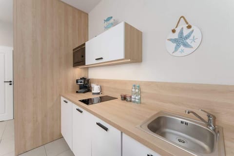 A closer view of the kitchen showcasing white cabinets, wooden countertops, and bright decorative touches.

