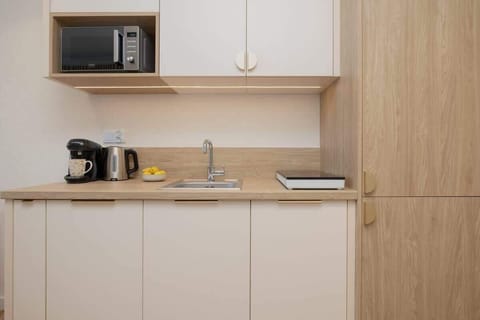 A bright kitchen with white cabinets, wooden finishes, and built-in appliances for functionality and style.
