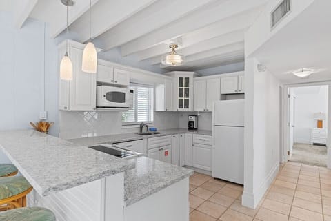 Full kitchen with bar stools, TV, and cozy nooka perfect space for cooking and casual dining.