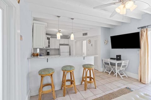 Full kitchen with bar stools, TV, and cozy nooka perfect space for cooking and casual dining.