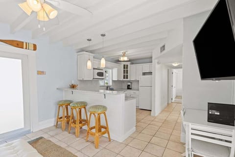 Full kitchen with bar stools, TV, and cozy nooka perfect space for cooking and casual dining.