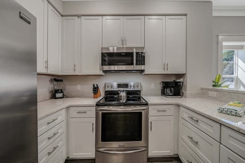 The fully equipped kitchen features beautiful recycled glass countertops and stainless-steel appliances.