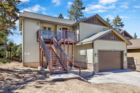 Welcoming cabin entry surrounded by towering pine trees, offering fresh mountain air and a peaceful forest setting—the perfect first impression for your Big Bear Lake getaway.