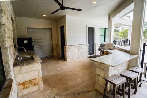 Outdoor kitchen has plenty to offer with sink, fridge, and built in grill. 