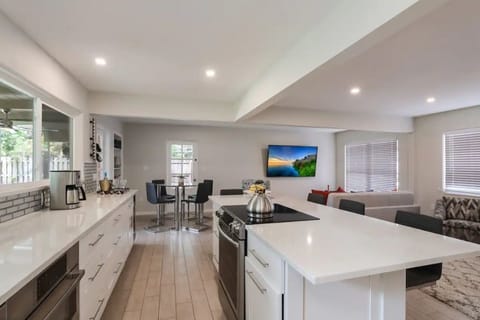 Expensive white kitchen cabinets, quartz countertops, glass backlash, fridge etc