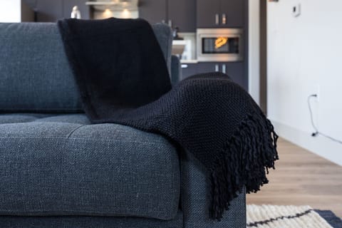 Bright living room with comfortable seating, smart TV, designer decor, and access to the private patio.