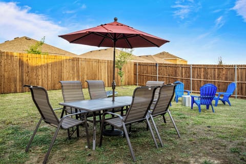 Spacious fully fenced backyard with outdoor dining table, chairs and patio umbrella. A great spot for construction crews and families to enjoy meals, fresh air and downtime during extended stays or insurance housing in Lavon.