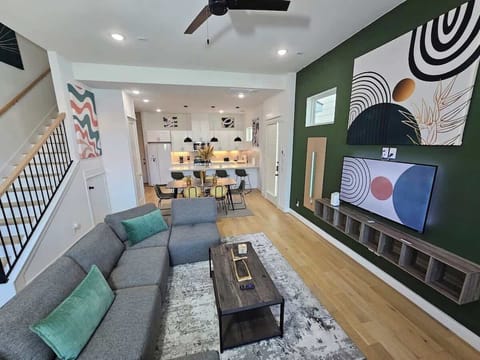 "Escape to luxury in our Mid-Century Modern haven. Green accent wall, LED sconces, and a TV make relaxation an art form."