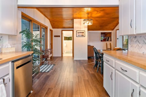 Kitchen flows seamlessly into the dining area, the powder room, and the queen bedroom