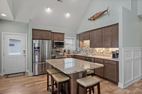 NH387C: Oak Island Cottage | Kitchen and Dining Area- Island Seating for 6