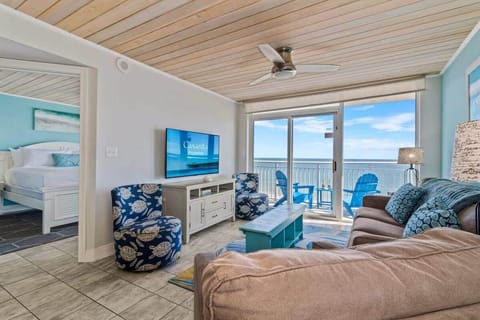 Relax in this bright and cozy living room featuring ocean-inspired decor, comfortable seating, and stunning balcony views. Perfect for unwinding after a day at the beach, this space invites you to soak in the coastal vibes in style.