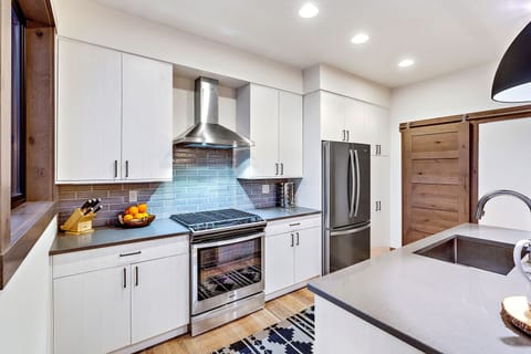 View of the kitchen; laundry area is located behind the wooden sliding door