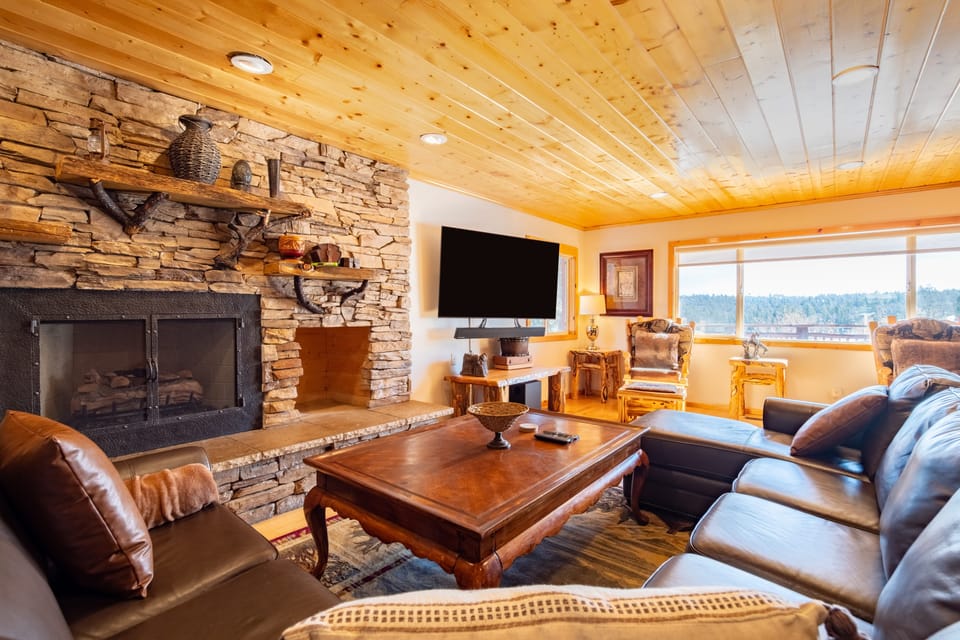 Elevated mountain design with a fireplace and TV in the living room.