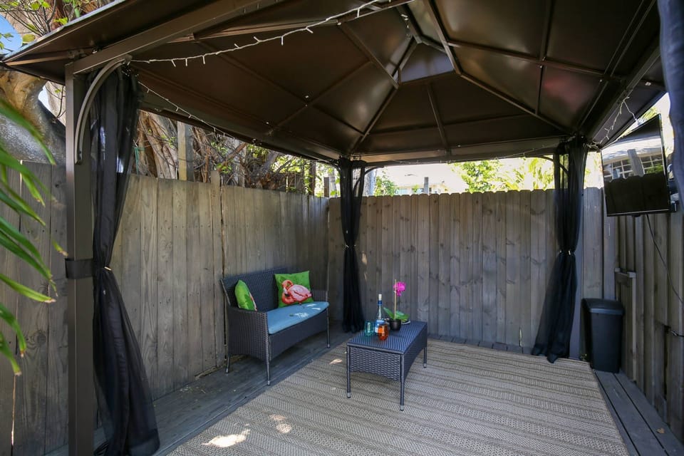 Covered outdoor area with seating and a TV.