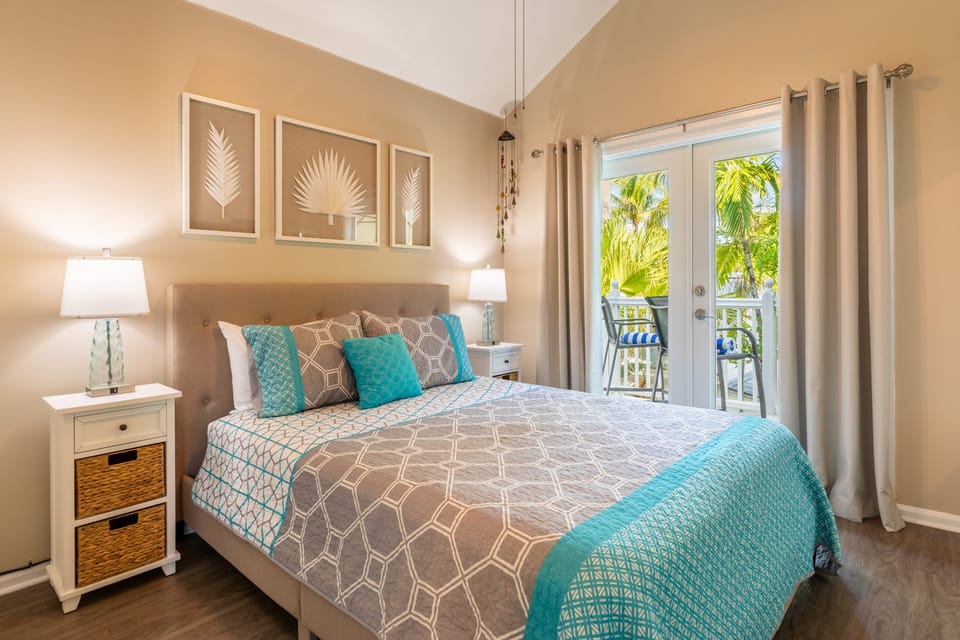 Primary bedroom features a queen bed, ensuite bathroom and access to balcony.