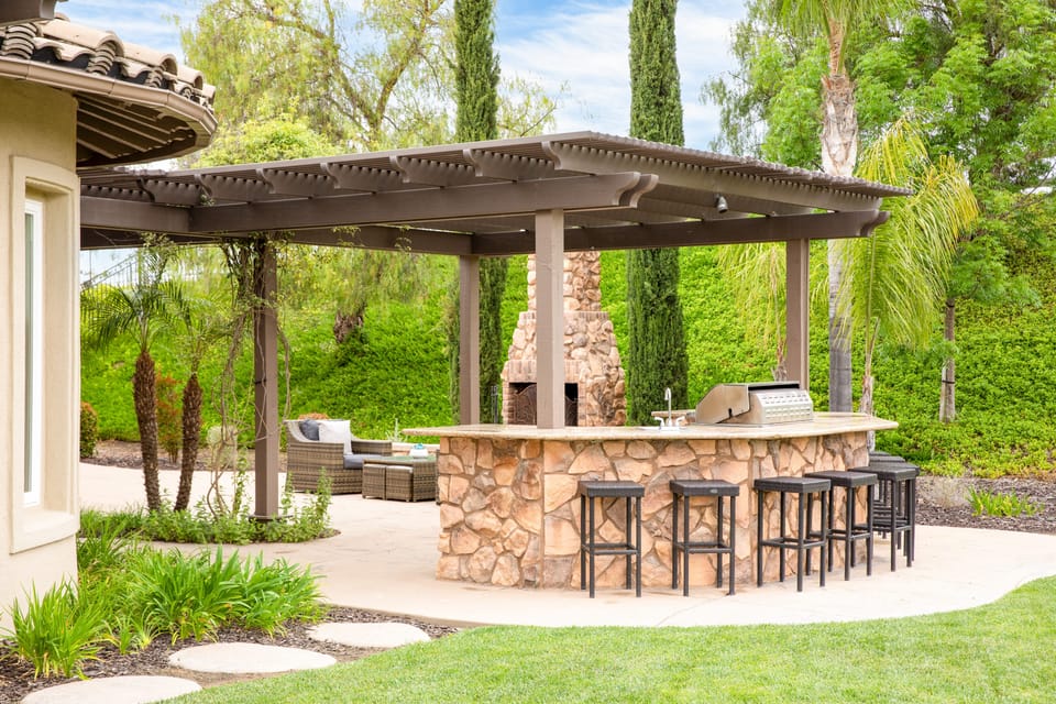 Outdoor fireplace lounge near the shaded grilling and bar area.