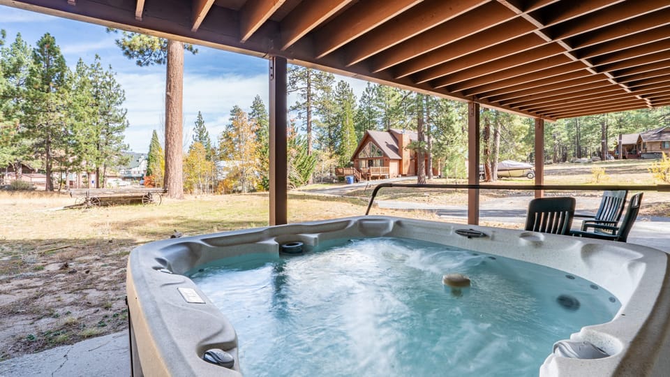 Covered patio with hot tub, seating, and BBQ grill.
