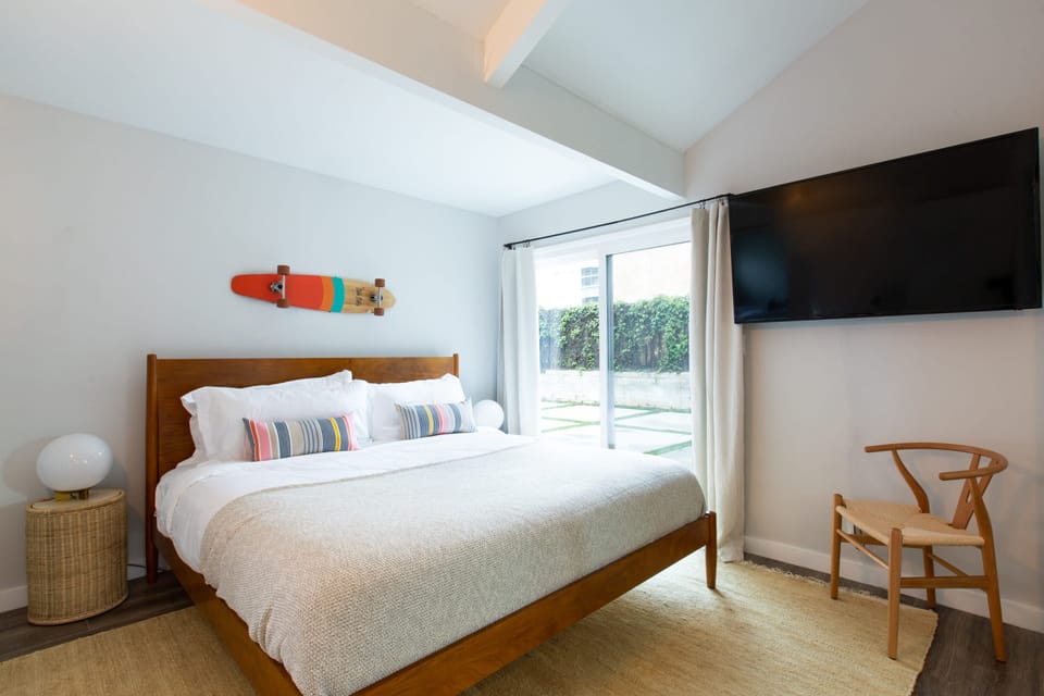 The primary bedroom features an ensuite, TV, and outdoor access.