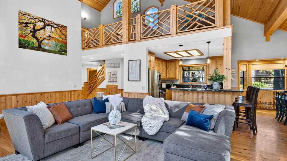 Open great room with lofted ceilings, a spacious sectional, and warm lodge-style finishes throughout.