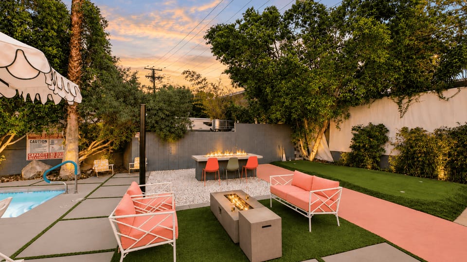 Gather around the glowing fire pit with colorful lounge seating and a peaceful garden backdrop.
