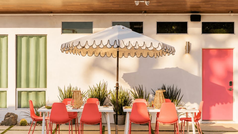 Thoughtful mid-century details bring personality to the studio, with a cozy green sofa and dining nook leading toward the patio.
