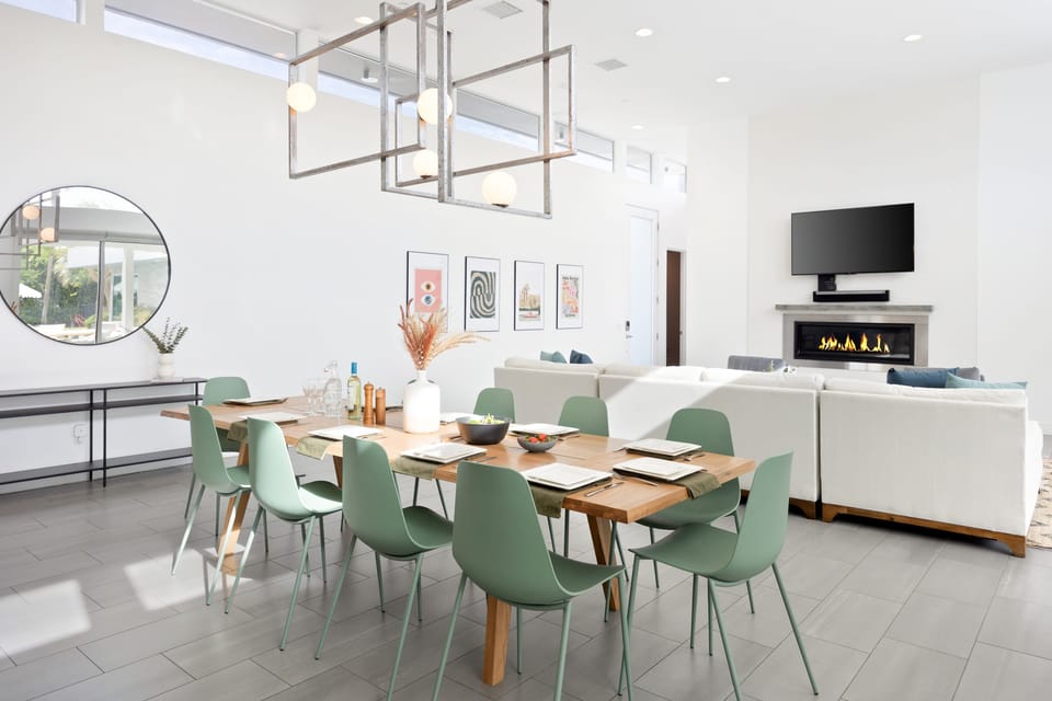 Poolside patio features an outdoor living area and a covered dining table.