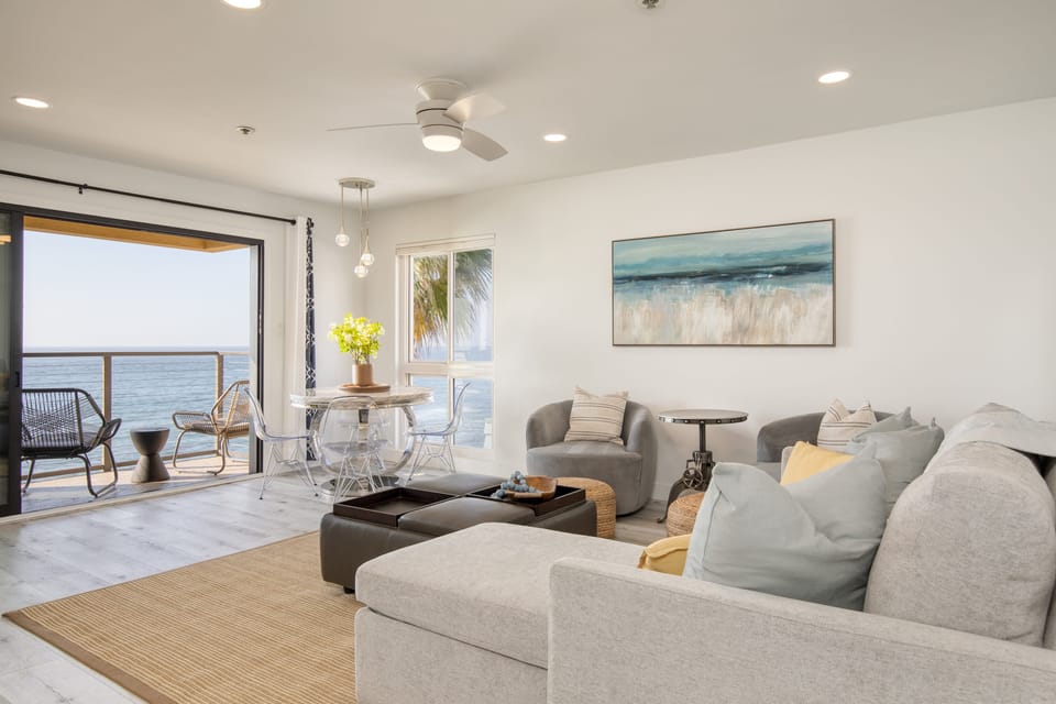 The living room features a sleeper sofa, TV, and dining table.