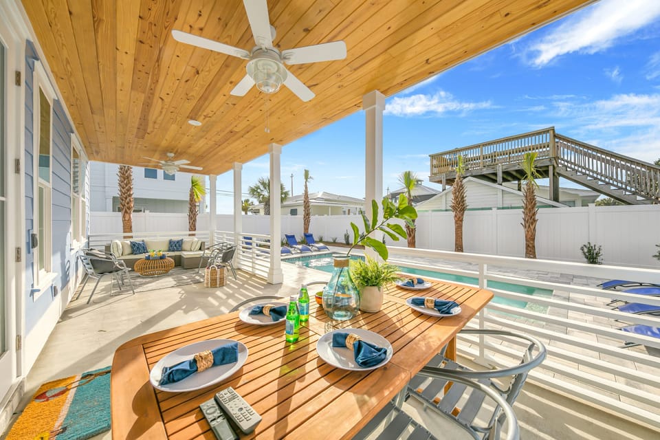 Covered patio with an outdoor dining table and lounge space.